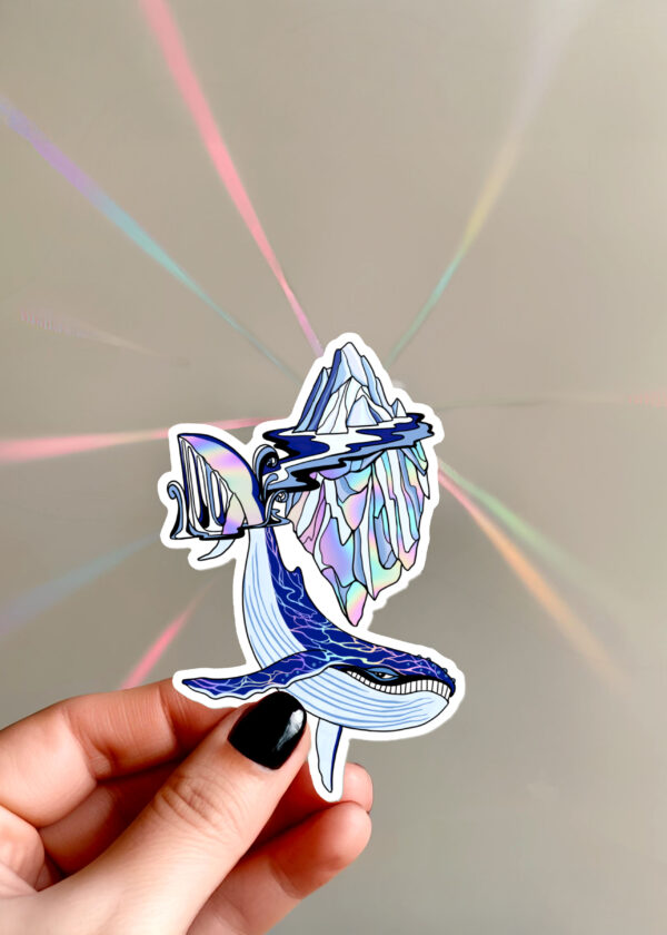 Sticker holographique Baleine magique avec une baleine à bosse souriante et un iceberg, doté d'un effet arc-en-ciel ultra-réfléchissant.